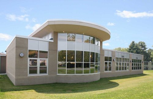 The school design gave Mosaic's architects a chance to define an entrance to the previously hard-to-find gymnasium by forming an exterior plaza with built-in benches.
