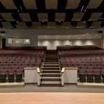 Mosaic’s theater design started with the replacement of a plaster ceiling which amplified ambient noise levels with reflector panels suspended over the seating.