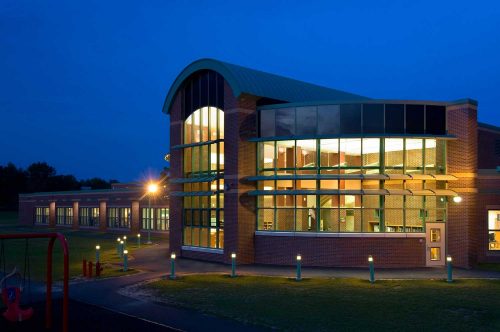Shatekon Elementary School design at night. By Mosaic Associates Architects.