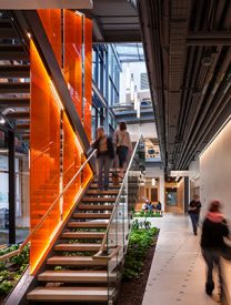 Artistic shot of a people on a daylight, industrial staircase in a public space. Background image for Mosaic Associates Architects Expertise web page